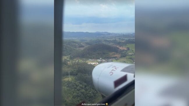 Captura de ecrã no formato vertical de história de rede social, exibindo uma vista aérea de paisagem rural e relevo montanhoso a partir da janela de uma aeronave, com a legenda "Acho que nasci pra isso" em sobreposição na parte inferior