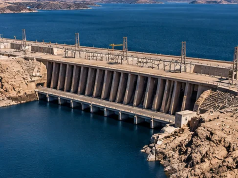 Vista aérea ilustrativa de uma grande barragem no Egito, com reservatório de água cercado por montanhas e terrenos áridos.