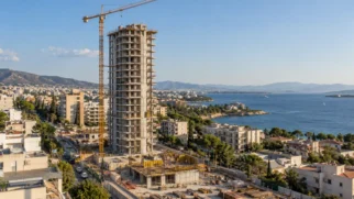 Vista da Riviera de Atenas com o Riviera Tower em construção, áreas urbanas, mar e parte do terreno do antigo aeroporto de Ellinikon.