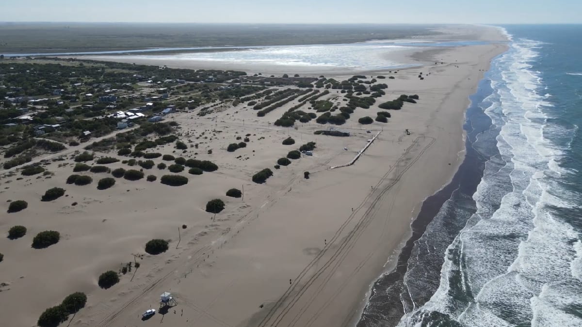 Praia de mar aberto e águas do rio Quequén Salado formam a paisagem do Balneário Oriente (Reprodução: UNA CASA DE MONTE/ YouTube)
