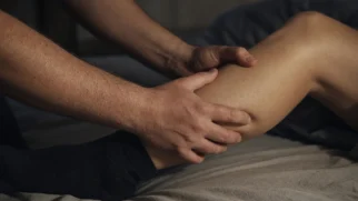 Mãos alongando panturrilha contraída durante cãibra noturna