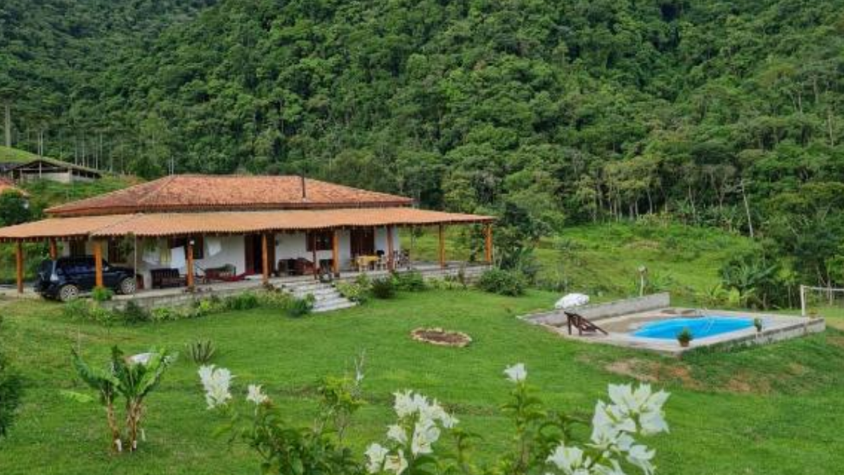 Refúgio dos Moreiras oferece casa de campo com piscina diante das montanhas; diária de referência é de R$ 675 (Foto: Reprodução / Booking.com)