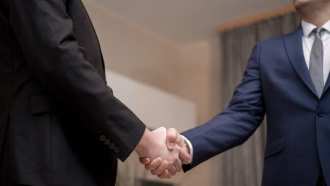 Homens de terno apertando as mãos
