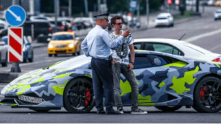 Maksim Yakubets, hacker russo que é considerado um dos cibercriminosos mais procurados do mundo, ao lado de seu carro de luxo