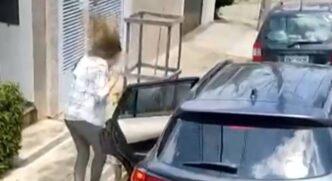 Quando os dois entram no veículo e a mulher parece ainda falar com eles, com a mão segurando a porta do carro, um tiro é disparado