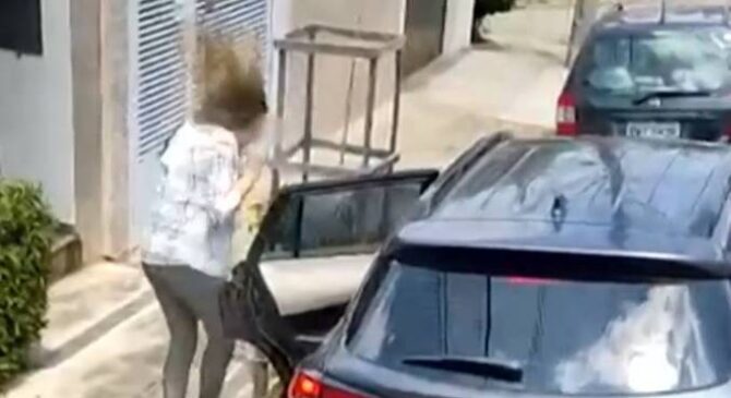 Quando os dois entram no veículo e a mulher parece ainda falar com eles, com a mão segurando a porta do carro, um tiro é disparado