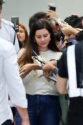 Lana Del Rey atende fãs ao desembarcar no aeroporto Santos Dumont no Rio de Janeiro.