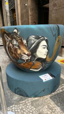 Xícara da artista NAI em frente ao Café IL Barista, na Rua João Brícola