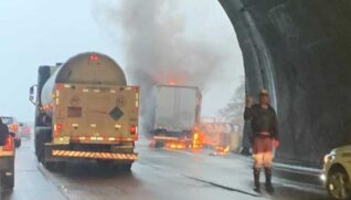 No vídeo, é possível ver o veículo no acostamento da Rodovia coberto pelas chamas e com uma coluna de fumaça ao redor.