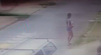Uma câmera de segurança capturou imagens da mulher momentos antes de ela cometer o crime se aproximando de um terreno baldio onde foi armada a fogueira