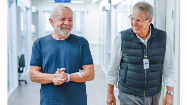 O presidente Lula caminha ao lado de médico após alta de UTI em São Paulo