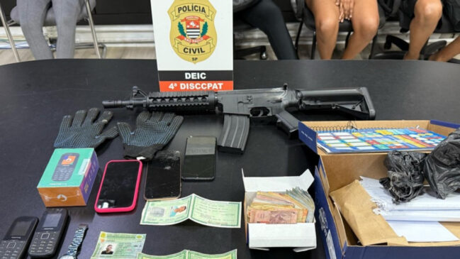 Casal foi preso com uma réplica de fuzil, celulares, luvas, relógio, anotações de contabilidade de comércio de drogas, porções de cocaína e R$ 875 em espécie