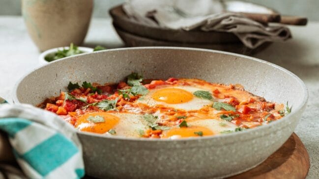 Existem várias maneiras de introduzir o ovo à sua alimentação, sem ser seguindo o óbvio: ovo cozido, mexido ou frito. Ovo de frigideira: aqueça uma frigideira com óleo, em fogo médio, quebre o ovo despeje com cuidado. Frite por 3 minutos, regando a clara com o óleo. Adicione molho de tomate e queijo. Tampe a frigideira até que o queijo derreta.