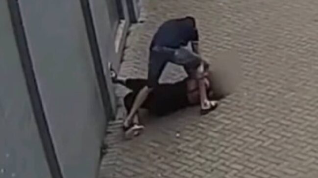 Imagens mostram o agressor abordando a vítima na calçada, arrastando-a até um muro e iniciando as agressões