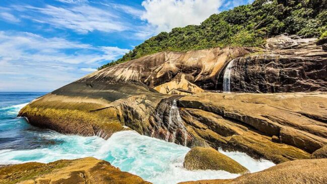A caminhada é longa e escorregadia, mas o poço cristalino com vista para o oceano é o ponto alto do Saco Bravo