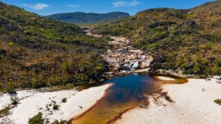 Vilarejo mineiro com cerca de 420 moradores atrai turistas por faixas de areia branca e poços naturais em meio às serras