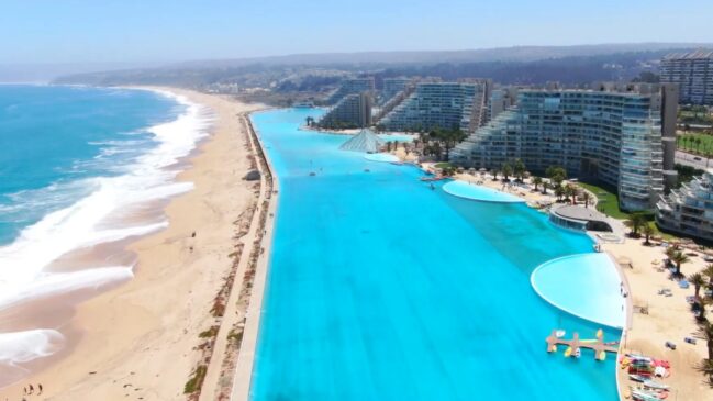 Contraste visual entre o azul profundo do Pacífico e a transparência cristalina da lagoa artificial é um dos pontos altos da visita