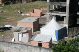 No terreno particular é possível ver três construções em tijolos e uma barraca de lona