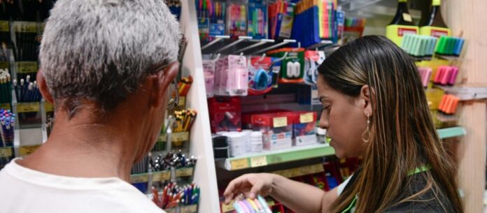 Vendedora da papelaria Femapel ajudando um cliente a comprar o material escolar, na capital paulista