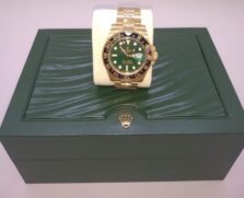 O item com o maior lance inicial é um relógio de pulso da marca Rolex, modelo GMT-Master II, com pulseira de ouro amarelo 18k