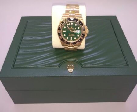 O item com o maior lance inicial é um relógio de pulso da marca Rolex, modelo GMT-Master II, com pulseira de ouro amarelo 18k