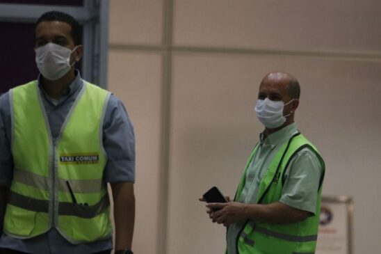 Passageiros e funcionários são vistos usando máscaras no Aeroporto Internacional Galeão, no RJ