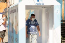 Usuário passa por dentro da cabine para se desinfectar