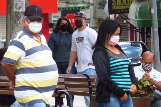 População usa máscara na rua para se prevenir ao novo coronavírus