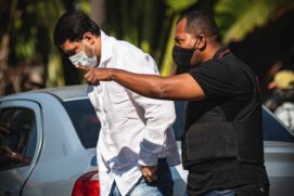 Marcos Duarte da Cruz, acusado de ser administrador oculto de instituto, sendo conduzido por agente do Ministério Público do Rio