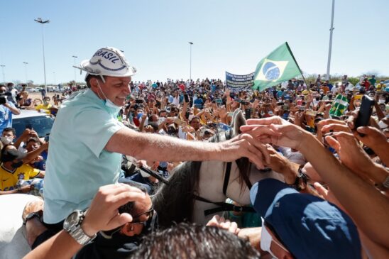 O presidente Jair Bolsonaro (sem partido) em meio à aglomeração em aeroporto nesta quinta-feira