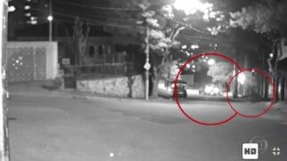 Um dos homens se aproxima do carro da vítima de 24 anos, que dá ré na tentativa de fugir e atinge outro veículo estacionado