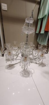 Entre os lotes, há um lustre de cristal com oito lâmpadas