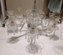 Entre os lotes, há um lustre de cristal com oito lâmpadas