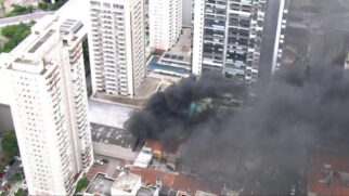 Uma extensa coluna de fumaça preta cobre a região