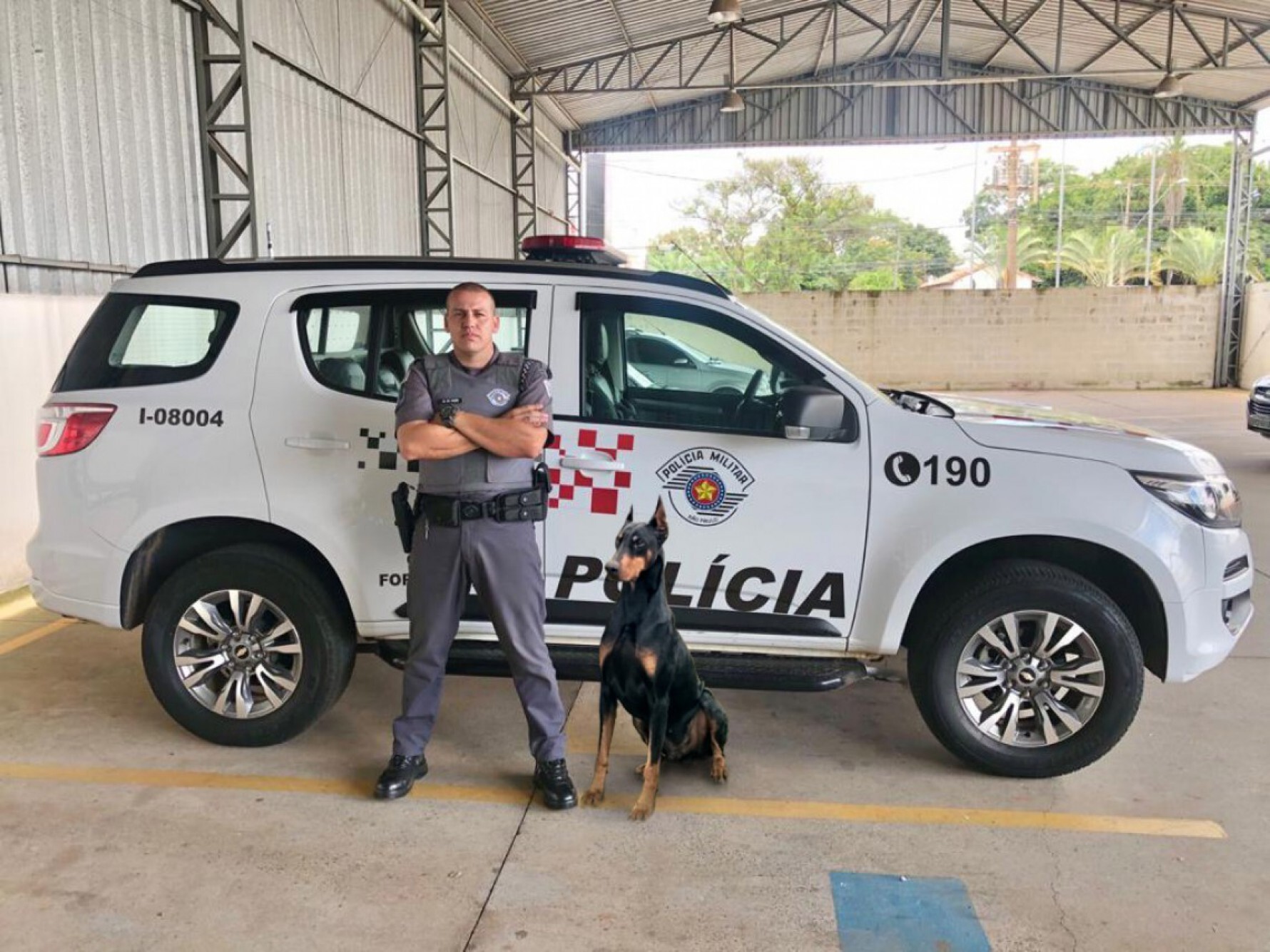 O cabo Cleber Ramin da Polícia Militar com um de seus cães