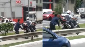 No vídeo, o policial aparece acelerando uma moto na qual um homem negro a esta algemado