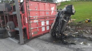 O motorista bateu na carreta que, com o impacto da batida, acabou tombando e derrubando o contêiner em cima do veículo